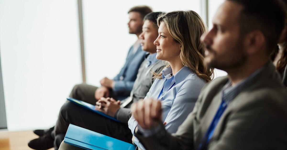 New sales hires listen to an onboarding session.