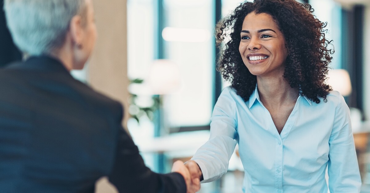 A seller greets an executive-level buyer for a meeting.