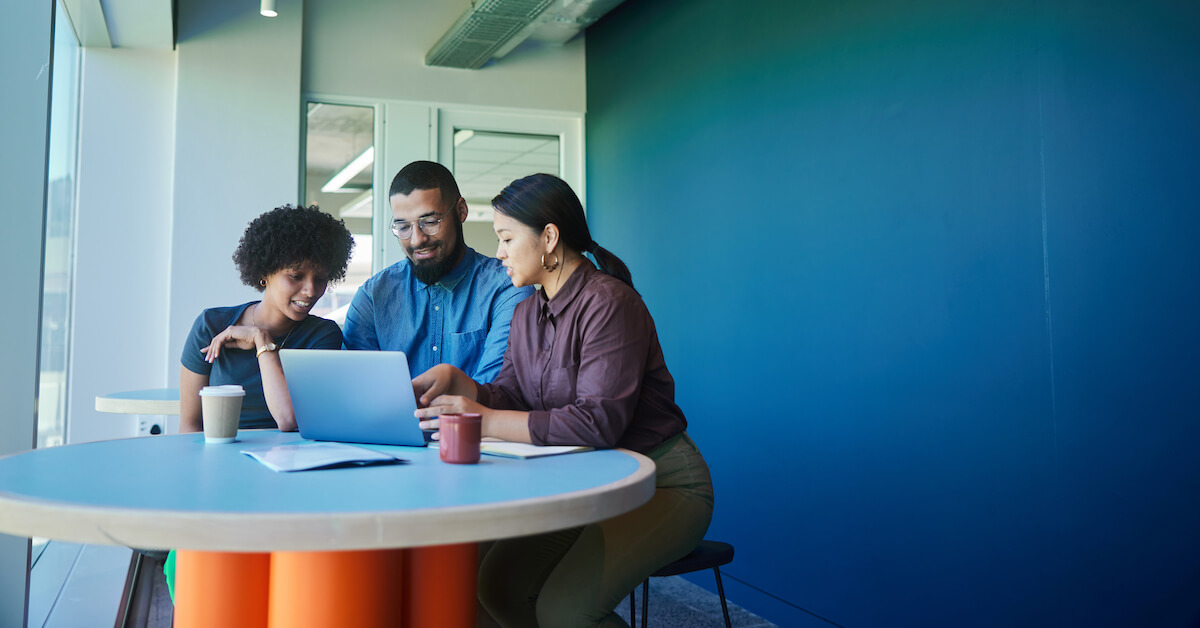 Three sellers sit at a table to explore and discuss AI tools.