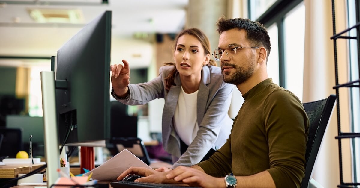 A sales coach and her colleague discuss the results of an AI roleplay simulation.