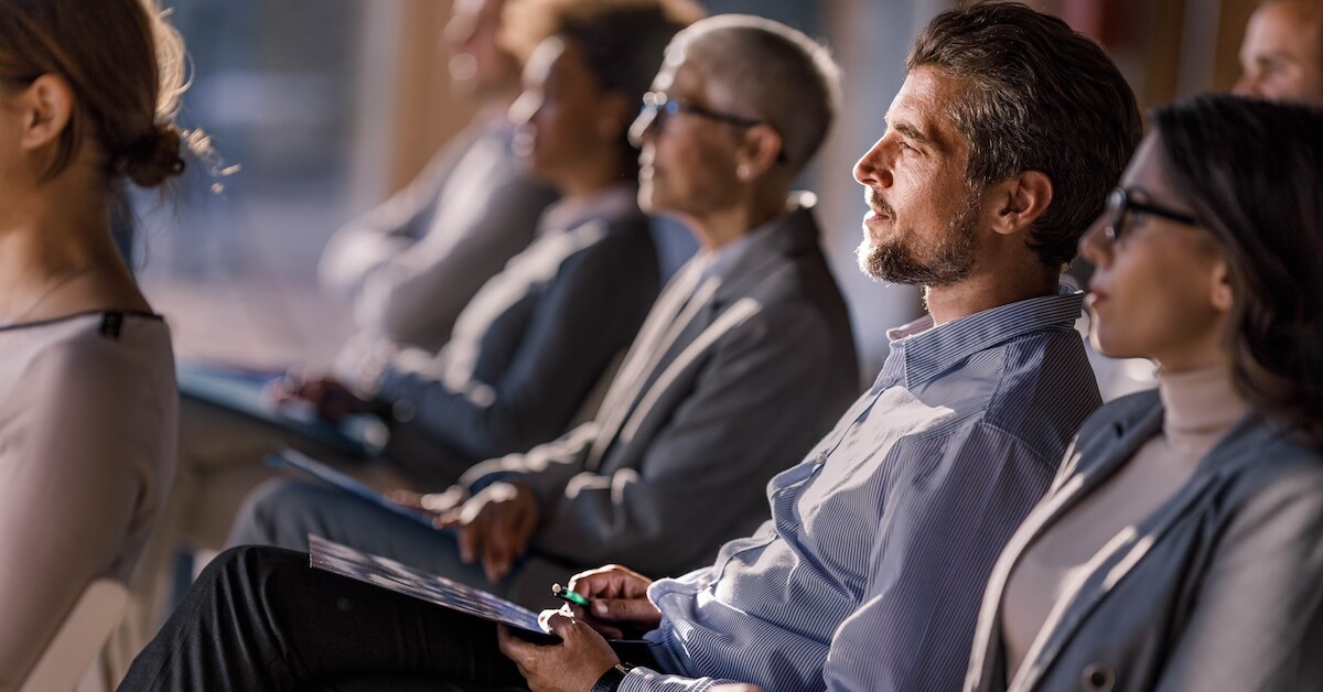 A cohort of sellers listen and take notes during upskilling training, as part of their company's everboarding program.