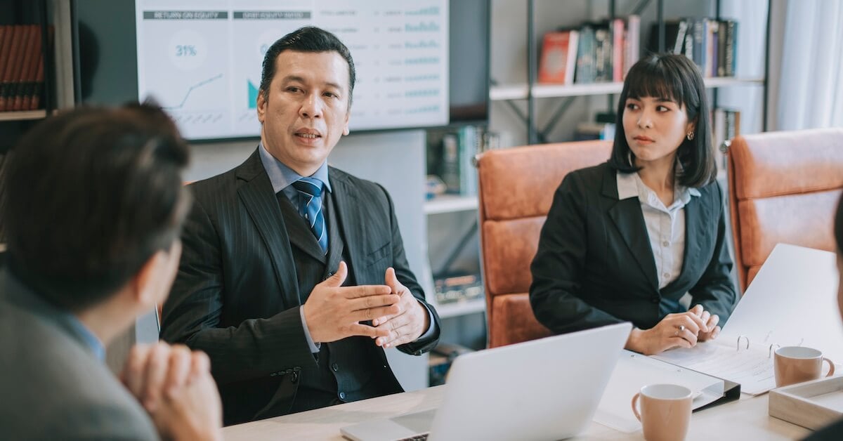 A manager begins a meeting with his sales team.