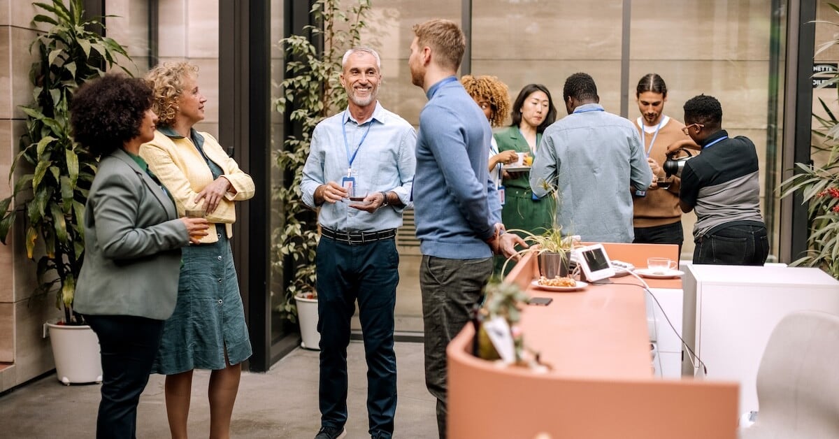 Sellers reconnect after a sales kickoff session to discuss learning.